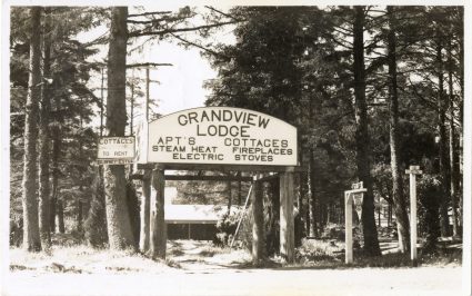 Archival black and white photo of the Grandview Lodge entrance sign among tall trees