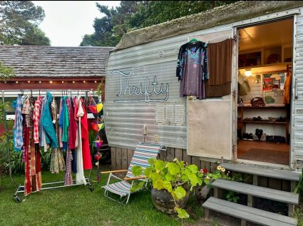 Thrifty trailer shop with a rack of clothes displayed outside its open door