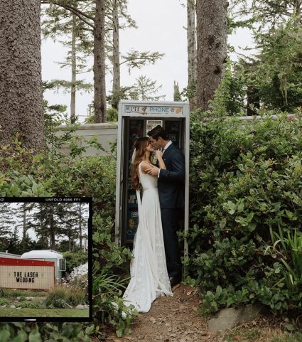 Bride and groom kiss beside a vintage phone booth surrounded by greenery