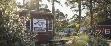 Sou'wester Lodge sign on a shed at the entrance, surrounded by tall trees